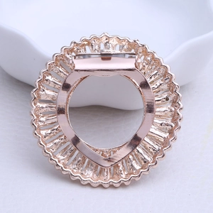 Detail of rose gold alloy scarf clip with intricate radial hollow pattern and metal buckle