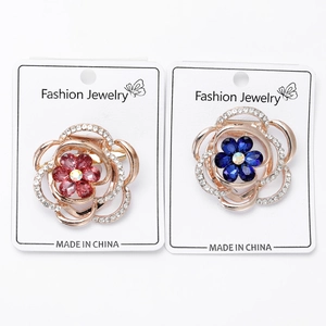 Detailed close-up of colorful crystal flower brooches with rose gold metal finish