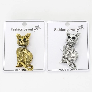 Detailed macro view of vintage cat brooches with gold and silver finishes and rhinestones