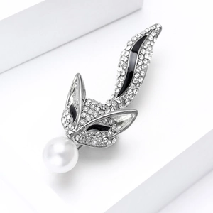 Vue détaillée d'une broche renard argentée avec strass pavés et une perle blanche