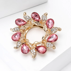 Detailed macro view of a floral scarf clip brooch with pink pear-cut gemstones and gold plating