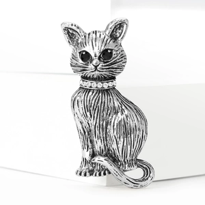 Close-up detail of vintage silver cat brooch with fur texture and crystal collar