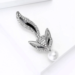 Gros plan détaillé d'une broche renard argentée avec strass brillants et une perle blanche