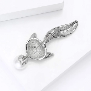 Détail du dos d'une broche renard avec perle et fermoir de sécurité rotatif