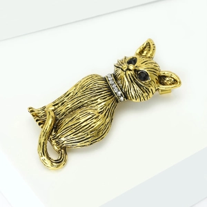 Detail view of retro cat brooch in antique gold finish with rhinestone collar and black gem eyes