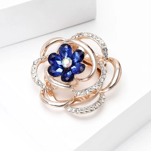 Macro shot of colorful glass floral scarf buckle with deep blue gems and golden petals