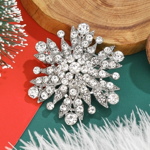 Vintage gun-black floral brooch with crystal rhinestones on a festive winter background