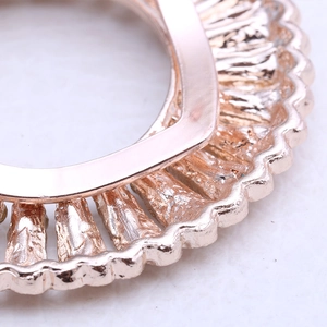 Detailed macro view of the rose gold plated wavy edge on a floral alloy silk scarf buckle