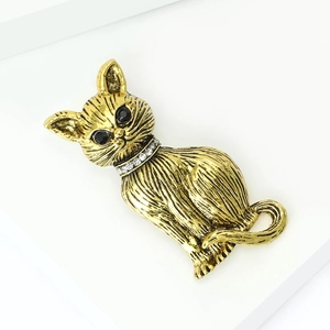Detailed view of vintage gold cat brooch featuring black rhinestone eyes and fur texture
