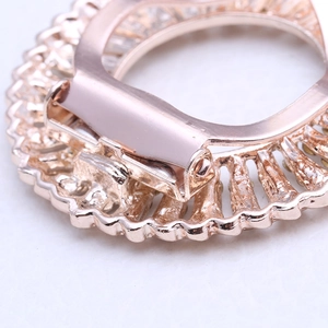 Macro detail of rose gold alloy brooch back showing secure metal clip and crystal setting