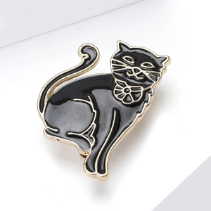 Detailed macro view of an elegant black enamel cat brooch with gold plating and floral bow tie