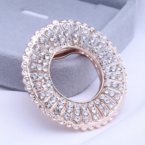 Macro shot of rose gold finish hollow ring brooch with sparkling paved white rhinestones