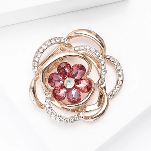 Detailed macro view of a rose gold flower brooch with pink rhinestones and glittering crystals