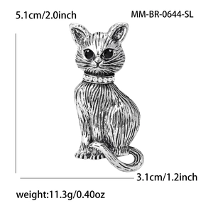 Vintage silver cat brooch with crystal collar and black gem eyes on white background