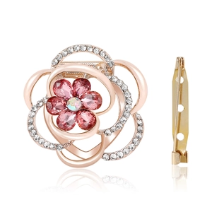 Rose gold floral brooch with pink crystals and white rhinestones on white background