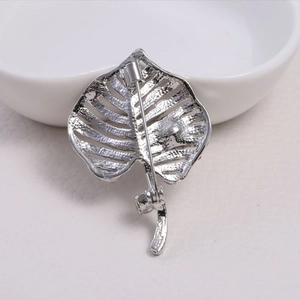 Silver monstera leaf brooch with elegant hollow design and back safety pin detail