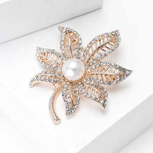 Macro detail of gold maple leaf brooch with pearls and shimmering pavé rhinestones