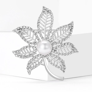 Elegant maple leaf brooch featuring a large center pearl and sparkling rhinestone crystals