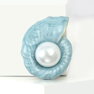 Eleganter Seeschnecke-Anstecker in Blau mit Perle und Goldrand auf hellem Untergrund