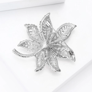 Detailed close-up showing the secure pin back and hollow metal craft of the maple leaf brooch