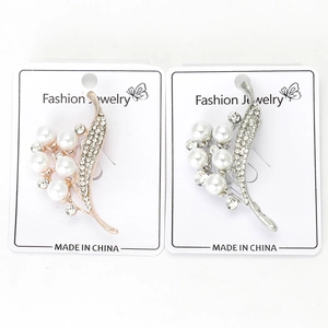 Détail de broches florales avec perles, finitions or rose et argent et strass brillants