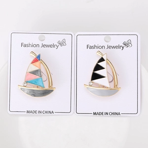 Detail of colorful enamel sailboat brooches with gold frames and sparkling rhinestones