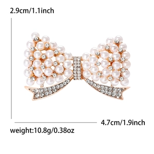 Broche nœud élégante avec perles et strass sur base plaquée or, dimensions 4,7cm x 2,9cm
