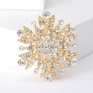 Macro shot of gold snowflake brooch with sparkling white rhinestones and detailed metalwork