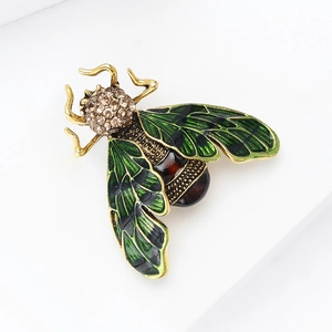 Close-up of vintage bee brooch featuring green enamel wings and brown gemstone belly