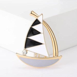 Detail of sailboat brooch featuring black and white enamel with a sparkling rhinestone