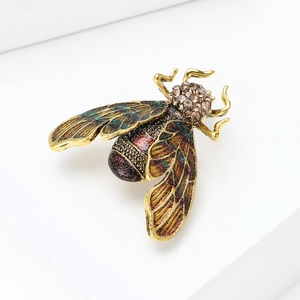 Detailed close-up of a bee brooch with green enamel wings and dark glitter body