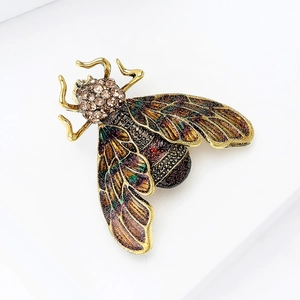 Macro shot of honey bee brooch with colorful enamel wings and sparkling rhinestones
