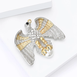 Broche aigle élégante bicolore argent et or avec cristaux et perle sur support blanc