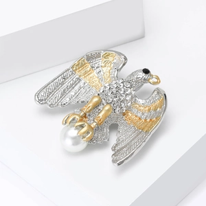 Broche aigle élégante avec strass blancs et une perle sur un socle géométrique