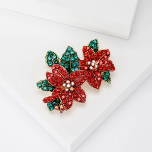 Eleganter Poinsettia-Blütenanstecker mit roten und grünen Kristallen auf Goldbasis