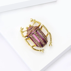 Detailansicht der Emaille-Käfer-Brosche mit rosa Strasssteinen auf Goldbasis