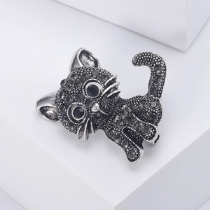 Detail of vintage silver cat brooch featuring pavé black rhinestones and large gem eyes