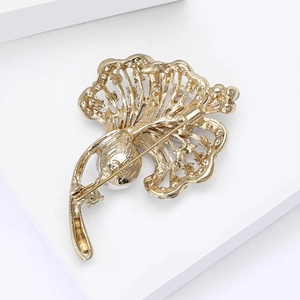 Detail of the golden leaf brooch back showing hollowed-out metalwork and safety pin clasp