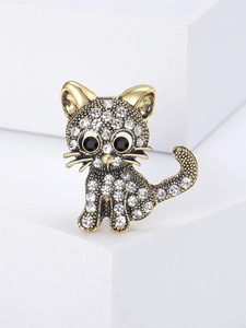 Macro detail of a vintage gold cat brooch with sparkling rhinestones and black gem eyes