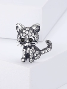 Detailed close-up of a silver cat brooch featuring white rhinestones and black gem eyes