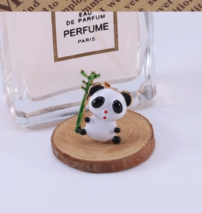 Vue détaillée d'une jolie broche panda en émail tenant une tige de bambou vert