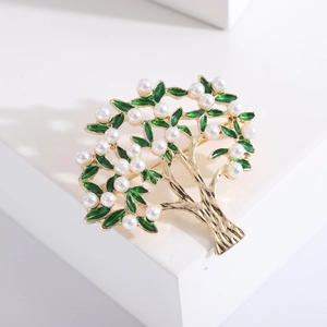 Vintage gold tree brooch with green enamel leaves and white pearls on white stone