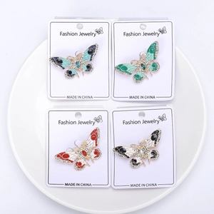 Vue détaillée de quatre broches papillon avec émail coloré et de fins strass brillants