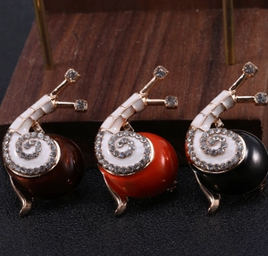 Detailaufnahme von Schnecken-Broschen mit Emaille und glitzernden Strasssteinen