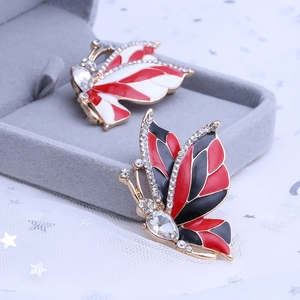 Detailed close-up of butterfly brooch showing colorful enamel wings and shiny crystal inlays