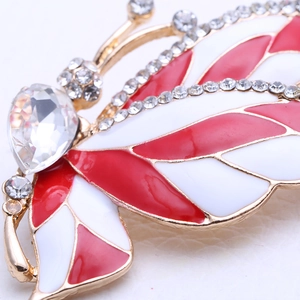 Macro shot of butterfly brooch with red enamel wings and sparkling crystal heart