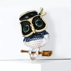 Detailed view of an owl brooch with oil drip feather texture and green zircon eyes