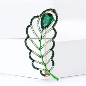 Elegant gold hollow leaf brooch with large emerald gemstone and colorful crystal accents