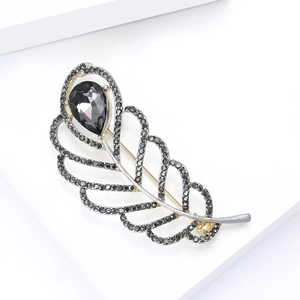 Detailed macro view of an elegant silver leaf brooch with black rhinestones and pear-cut gem