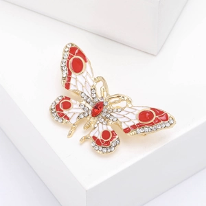Gros plan détaillé d'une broche papillon en émail rouge avec des cristaux brillants